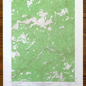 May include: A vintage topographic map of the Roosevelt National Forest in Colorado. The map shows elevation contours, rivers, and other geographical features. The map is printed on paper and has a green and brown color scheme.