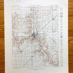 May include: A vintage topographic map of Danville, Illinois, showing the city's layout and surrounding areas. The map features contour lines, rivers, roads, and other geographical features. The map is printed on a white background with brown and blue lines.