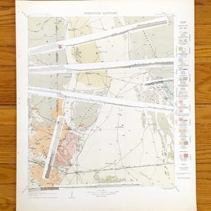 May include: A vintage geological map titled "Structure Sections" with various coloured areas and lines. The map features a legend on the right side and is printed on aged paper. The map is displayed on a wooden surface.