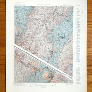 Peut inclure: Une carte géologique vintage de la région frontalière entre la Pennsylvanie et le New Jersey, montrant la structure géologique de la région. La carte est imprimée en noir et blanc avec des lignes et des marques colorées pour indiquer les différentes formations géologiques. La carte comprend une légende expliquant les différents symboles utilisés.