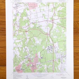 Puede incluir: Un mapa topográfico vintage del área de Greenburgh, NY, que muestra carreteras, ríos y áreas boscosas. El mapa está impreso en papel y tiene un esquema de color verde, marrón y rojo. El mapa está titulado "Greenburgh, N.Y."