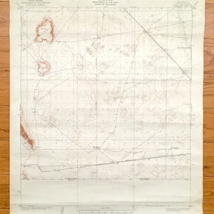 Può includere: Una mappa topografica vintage di una regione desertica con linee di livello e indicazioni di altitudine. La mappa è intitolata "UNITED STATES DEPARTMENT OF THE INTERIOR GEOLOGICAL SURVEY" e "UNITED STATES DEPARTMENT OF THE ARMY CORPS OF ENGINEERS".