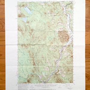 Puede incluir: Un mapa topográfico vintage de la zona de Averill, Vermont. El mapa muestra las ciudades de Averill, Lemington, Bloomfield, Brunswick y Stratford. El mapa está impreso en papel de color crema con líneas y texto marrones y verdes.