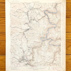 Può includere: Una mappa topografica vintage del Great Smoky Mountains National Park, che mostra il terreno del parco, i fiumi e le strade. La mappa è stampata in bianco e nero con accenti marroni e blu.
