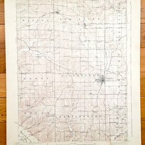 May include: A vintage map of Illinois, showing the towns of Pittsfield, New Salem, Martinsburg, and surrounding areas. The map is printed on cream-colored paper and features brown lines and text.