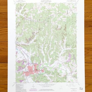 May include: A topographic map of a rural area, featuring contour lines, roads, and a town marked in red. The map includes text indicating the state of Iowa and the U.S. Department of the Interior. The map is printed on white paper.