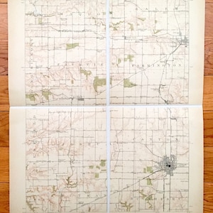Op de afbeelding: Een vintage kaart van het gebied van Canton, Missouri. De kaart is verdeeld in vier secties, die elk een ander deel van de stad laten zien. De kaart is gedrukt op crèmekleurig papier en bevat de namen van steden, wegen en andere kenmerken.