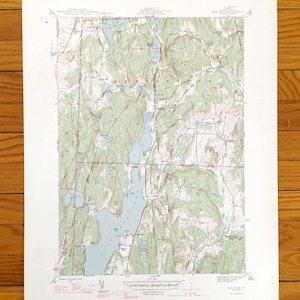 Pode incluir: Um mapa topográfico vintage da área de Monadnock, New Hampshire. O mapa mostra a localização de lagos, rios, montanhas e estradas. O mapa é impresso em papel branco com linhas verdes e marrons.