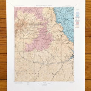 May include: A vintage map of the Artesian Water Sheet in Maxwell Grant, New Mexico. The map is printed on paper and shows the location of water sources and other geographical features. The map is in black, white, and shades of blue and pink.
