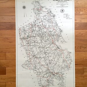 May include: A vintage map of Plymouth County, Massachusetts, showing roads and towns. The map is printed on white paper with black and red lines. The title "Highway Map of Plymouth County, Massachusetts" is printed at the top of the map. The map was compiled from various sources by Lewis W. Perkins, County Engineer, 1928.