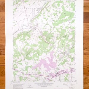 以下が含まれることがあります： ハイブリッジ、NJのヴィンテージ地形図。詳細な等高線、道路、地理的特徴が描かれています。緑、紫、茶色の色合いの古紙に印刷されており、地図の起源と縮尺を示すテキストが含まれています。