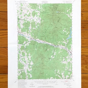 May include: A vintage topographic map of the Carrabassett, Maine area. The map shows the location of roads, rivers, lakes, and mountains. The map is printed on white paper with green lines and text.
