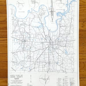 Könnte beinhalten: Eine Vintage-Straßenkarte von Cooke County, Texas, mit detaillierten Straßennetzen, Gewässern und Insets von Oklahoma. Die Karte ist in Schwarz und Blau auf weißem Hintergrund gedruckt, mit einer Legende und einem Maßstab unten.
