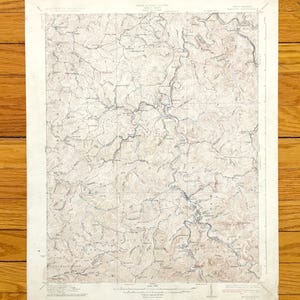 May include: A vintage topographic map of the West Virginia area, showing rivers, roads, and elevation contours. The map is printed on cream-coloured paper and has a brown and black colour scheme.