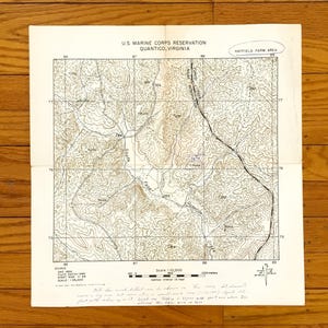 Puede incluir: Un mapa topográfico en blanco y negro de la Reserva del Cuerpo de Marines de los Estados Unidos en Quantico, Virginia. El mapa muestra el área de la granja Hayfield e incluye líneas de contorno, puntos de elevación y características geográficas. El mapa está titulado "U.S. Marine Corps Reservation Quantico, Virginia" y "Hayfield Farm Area".