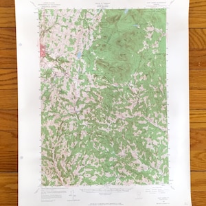 Puede incluir: Un mapa topográfico de East Burke, Vermont, con relieve sombreado en verde y blanco, curvas de nivel y elementos etiquetados. El mapa está impreso en papel blanco e incluye detalles del Departamento del Interior de los Estados Unidos y del Estado de Vermont.