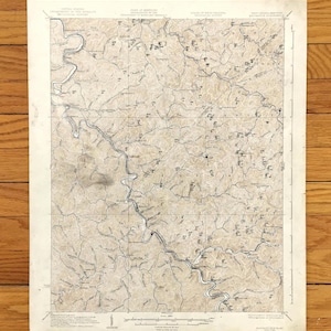 Op de afbeelding: Een vintage topografische kaart van het gebied rond de stad Sparta, North Carolina. De kaart is gedrukt op crèmekleurig papier en toont het terrein, rivieren en wegen van het gebied. De kaart is gedateerd 1953.