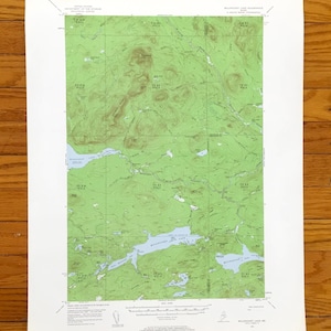 May include: A vintage topographic map of the Willimantic Lake, Maine area. The map features green and brown contour lines, indicating elevation changes, and blue areas representing lakes and rivers. The map is printed on white paper.