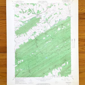 May include: A vintage topographic map of Spring Mills, Pennsylvania, featuring green shaded relief for forested areas and contour lines. The map includes place names and grid lines, printed on aged paper.