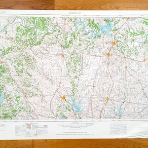 May include: A detailed map of Sherman, featuring roads, rivers, and green-shaded areas representing forests. The map includes the text "Sherman" at the top and various other labels and legends. The map is printed on a white sheet.