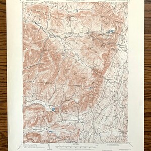 May include: A vintage topographic map of the Kaaterskill Quadrangle in New York, featuring detailed contour lines and place names like Woodstock and Hunter. The map is printed in shades of brown and blue, with text indicating the Department of the Interior and Geological Survey.