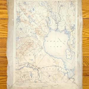 May include: An antique map of Sebago Lake in Maine, showing the surrounding towns of Naples, Baldwin, Standish, and Limington. The map is printed on aged paper with faded ink and includes topographical details.