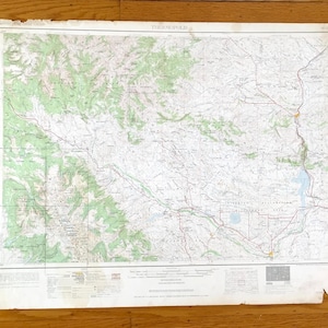 May include: A vintage topographical map with green, brown, and white details. The map shows geographical features, roads, and place names. The map is aged, with some wear and tear around the edges.