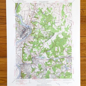 Puede incluir: Un mapa topográfico detallado de una zona, con curvas de nivel, masas de agua y áreas sombreadas en verde que representan bosques. El mapa incluye texto que indica el Departamento del Interior de los Estados Unidos y el Estado de Massachusetts.