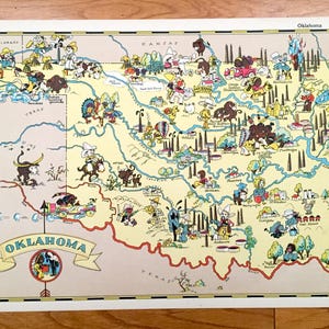 Puede incluir: Un mapa ilustrado vintage de Oklahoma con personajes de dibujos animados y puntos de referencia. El mapa está sobre un fondo blanco con un borde amarillo y la palabra "Oklahoma" en una pancarta roja en la parte inferior.