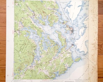 May include: A vintage map of the coast of Maine, USA, showing the towns of Rockland, Camden, and Belfast. The map is printed on paper and has a light blue and green color scheme. The map is titled "UNITED STATES DEPARTMENT OF THE ARMY,  COAST OF MAINE,  1947."