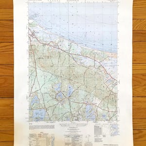 Può includere: Una mappa vintage di Sandwich, Massachusetts, con informazioni topografiche dettagliate. La mappa mostra strade, corpi idrici e caratteristiche geografiche in tonalità di blu, verde e marrone. Il titolo "Sandwich" è stampato in alto.