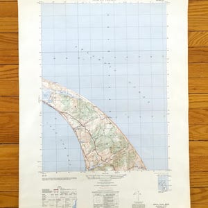 Può includere: Una mappa vintage di North Truro, Massachusetts, con un motivo a griglia blu e bianco. La mappa presenta una rappresentazione dettagliata della costa, con masse terrestri verdi e marroni. Il titolo "North Truro" è visibile in alto.