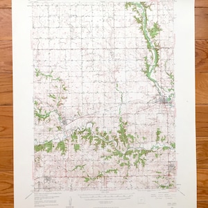 Peut inclure: Une carte topographique vintage d'Adel, Iowa, montrant le terrain, les rivières et les routes de la région. La carte est imprimée sur du papier blanc avec des lignes et du texte bruns et verts. La carte est intitulée "Adel Quadrangle, Iowa" et comprend le texte "United States Department of the Interior Geological Survey".