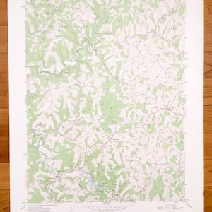 May include: A vintage topographic map of Wind Ridge, Pennsylvania, showing the area's terrain, rivers, and roads. The map is printed on paper and has a green and brown colour scheme. The map includes the text "Wind Ridge Quadrangle" and "Wind Ridge, PA".