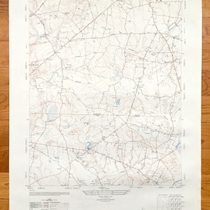 May include: A vintage topographic map of Adelphia, New Jersey, showing roads, rivers, and elevation contours. The map is printed on cream-coloured paper with blue and brown lines. The map title "Adelphia, New Jersey" is printed in the bottom right corner.