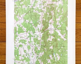 May include: A vintage topographic map of the Charlton, Massachusetts area. The map shows the terrain, roads, and waterways of the region. The map is printed in black and green on white paper.