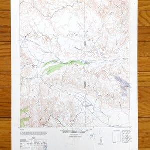 May include: A topographic map of Carrizo Mountain, California, featuring contour lines, elevation markings, and geographical features. The map includes text labels and a legend, with shades of brown, green, and blue. The map is printed on white paper.