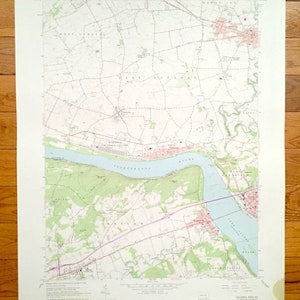 Peut inclure: Une carte vintage de Columbia West, en Pennsylvanie, montrant la rivière Susquehanna, les routes et les villes. La carte est imprimée sur un fond blanc avec des accents verts et bleus. La carte est intitulée "Columbia West, PA" et comprend le texte "United States Department of the Interior Geological Survey" et "State of Pennsylvania Department of Internal Affairs".
