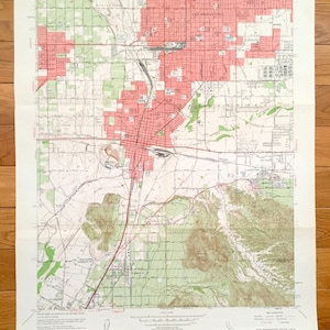 May include: A vintage topographic map of San Bernardino South Quadrangle, California, showing roads, rivers, and elevation contours. The map is printed on paper and has a light brown color.