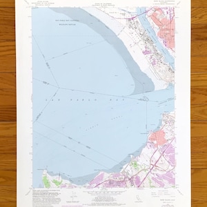 Puede incluir: Un mapa antiguo de la bahía de San Pablo, California, con cartografía detallada. El mapa presenta la bahía en azul claro, con áreas terrestres en tonos verdes, rosas y morados. El texto incluye "San Pablo Bay National Wildlife Refuge" y otros detalles geográficos.
