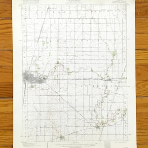 Peut inclure: Une carte topographique vintage intitulée "TOPOGRAPHIE". La carte, imprimée à l'encre noire sur papier crème, présente des lignes détaillées, des quadrillages et des noms de lieux. La carte rectangulaire représente un paysage rural.