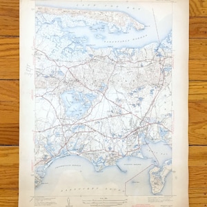 Può includere: Una mappa topografica vintage di Cape Cod Bay e Nantucket Sound, con dettagliati contorni del terreno, corpi idrici e reti stradali. La mappa è stampata su carta invecchiata in una combinazione di blu chiaro e bianco, con nomi di luoghi.