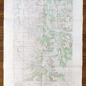 Peut inclure: Une carte topographique vintage de la région de Stanton, Minnesota. La carte montre l'emplacement de la forêt d'État de bois dur du mémorial du Minnesota et de la ville de Stanton. La carte est imprimée sur un fond blanc avec des lignes vertes et brunes.