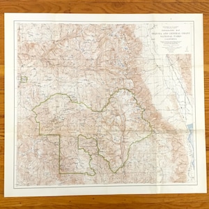May include: A topographic map of Sequoia and General Grant National Parks, California. The map features detailed contour lines, shaded relief, and green boundary lines. The map is printed on aged paper with a cream-colored border.