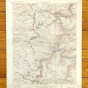 Può includere: Una mappa topografica vintage della West Virginia, con dettagliate curve di livello, fiumi e strade. La mappa è stampata su carta invecchiata, con testo in alto che indica il Dipartimento degli Interni e lo Stato della West Virginia.