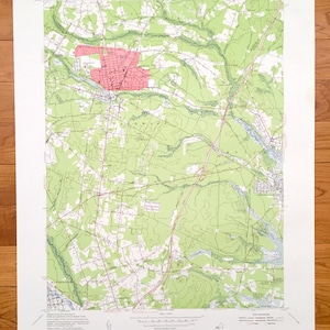 May include: A vintage topographic map of the area around Lakewood, New Jersey. The map is printed on paper and shows the roads, rivers, and other features of the area. The map is in a green and brown colour scheme.