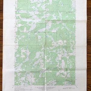 May include: A vintage topographic map of the Milaca NE quadrangle in Minnesota. The map shows the location of the Mille Lacs State Wildlife Management Area, the Rum River State Forest, and various other features. The map is printed on a white background with green lines and text.