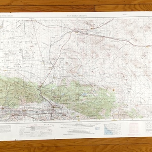 Könnte beinhalten: Eine Vintage-topografische Karte von San Bernardino, Kalifornien, die die Umgebung mit detaillierten Höhenlinien und geografischen Merkmalen zeigt. Die Karte ist auf Papier gedruckt und hat einen weißen Hintergrund mit schwarzen Linien und braunem Text.