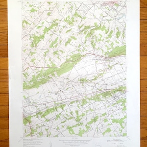 May include: A vintage topographic map of the Malvern, PA area. The map shows roads, rivers, and other geographical features. The map is printed on white paper and has a green and brown color scheme.