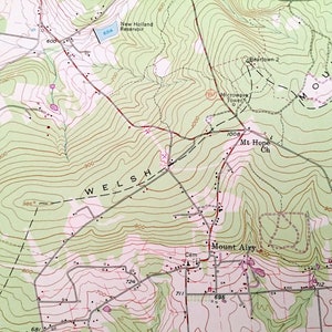 Op de afbeelding: Een topografische kaart die het gebied rond Mount Airy, het New Holland Reservoir en de Mt Hope Church laat zien. De kaart toont hoogtelijnen, wegen en andere geografische kenmerken. De tekst "WELSH" is zichtbaar op de kaart.